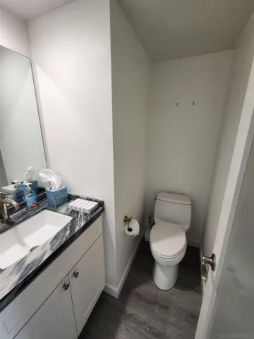 a bathroom with a granite countertop toilet a sink and a mirror