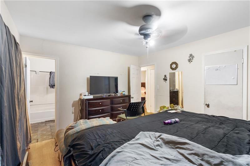 1496 Meadowlark Drive Decatur, GA 30032 - Photo 11 of 27 a bedroom with a bed and a flat tv screen on a dresser