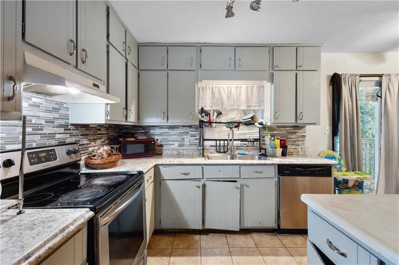 1496 Meadowlark Drive Decatur, GA 30032 - Photo 8 of 27 a kitchen with stainless steel appliances a stove sink and cabinets