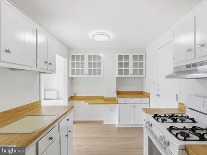 a kitchen with stainless steel appliances granite countertop a stove and a white cabinets