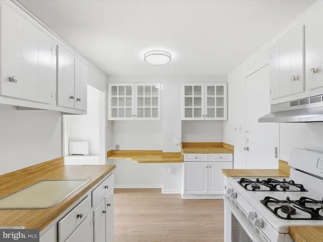 a kitchen with stainless steel appliances granite countertop a stove and a white cabinets