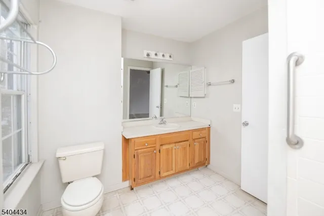 a bathroom with a granite countertop sink a toilet and a mirror