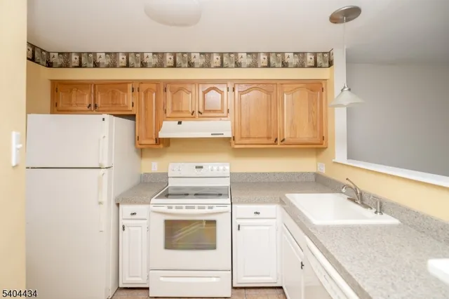 a kitchen with a refrigerator a stove a sink and a cabinets