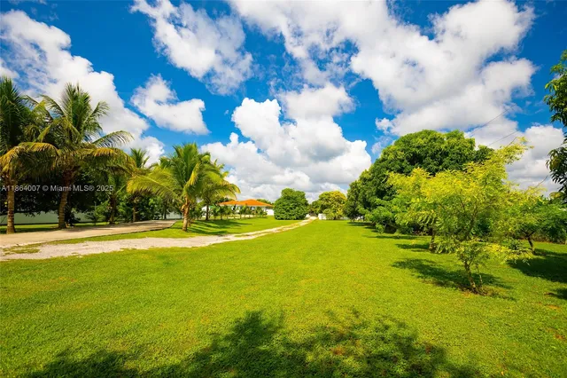 a living room with stainless steel appliances kitchen island granite countertop a table chairs and a refrigerator