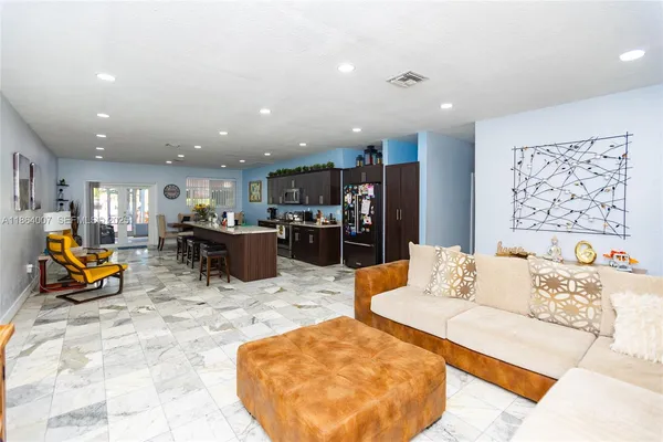 a row of palm trees and a fire pit in the backyard of the house