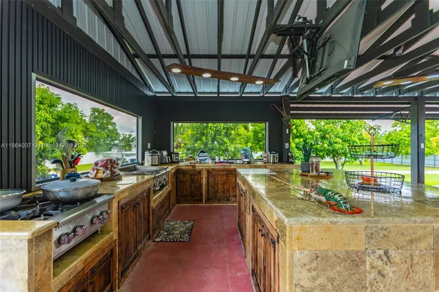 a living room with furniture kitchen view and a wooden floor