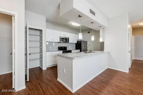a kitchen with cabinets and wooden floor
