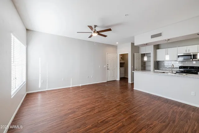 a view of a kitchen with a fridge and wooden floor