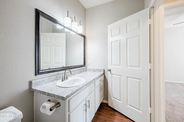 a spacious bathroom with a granite countertop sink and a mirror