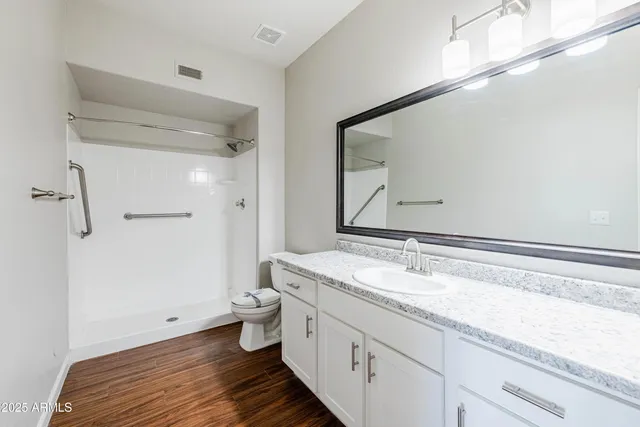 a spacious bathroom with a granite countertop sink and a mirror