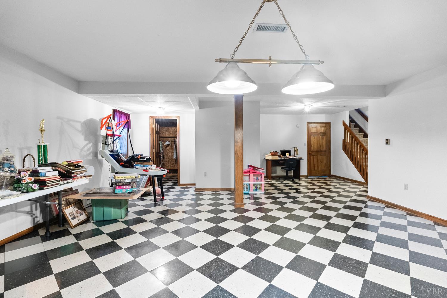 1159 Cifax Road Forest, VA 24551 - Photo 39 of 60 a living room with a black white checkered floor with a gaming machine and dining chairs