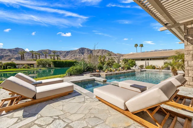 a view of a patio with couches table and chairs and potted plants