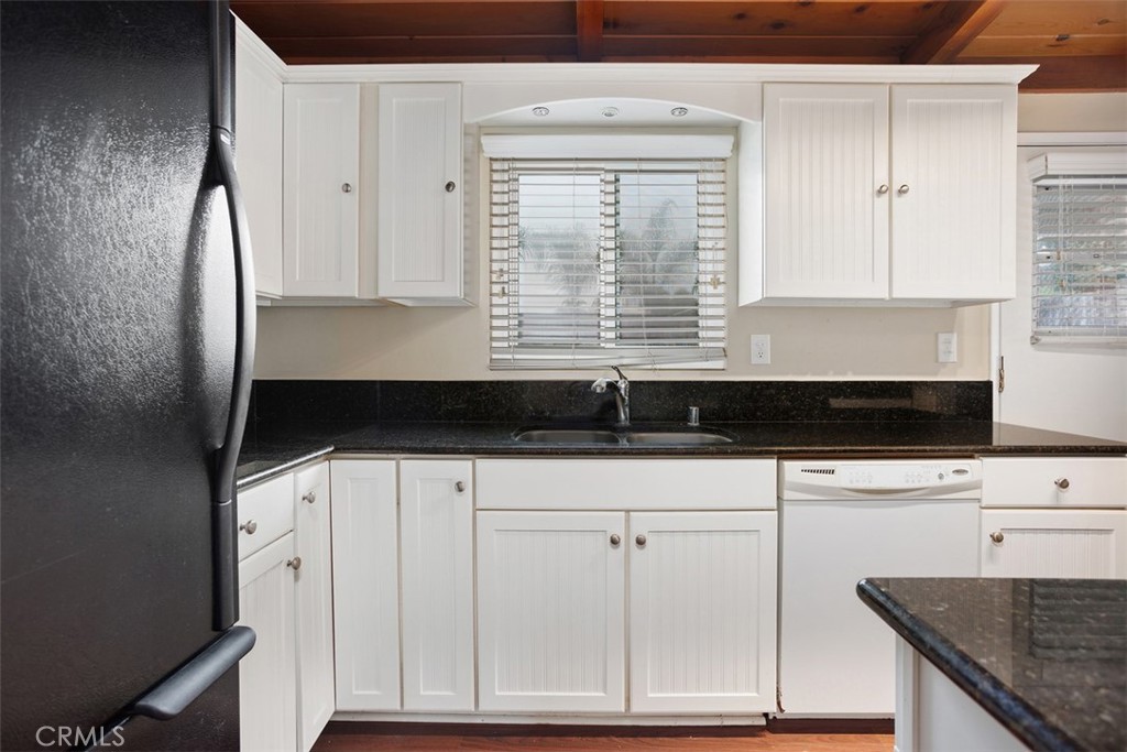 1710 Valley Place Carlsbad, CA 92008 - Photo 13 of 31 a kitchen with granite countertop white cabinets and white appliances