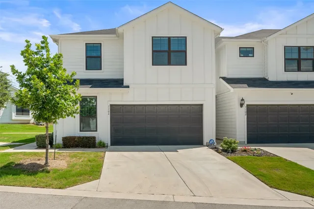 a front view of a house with a yard and a garage