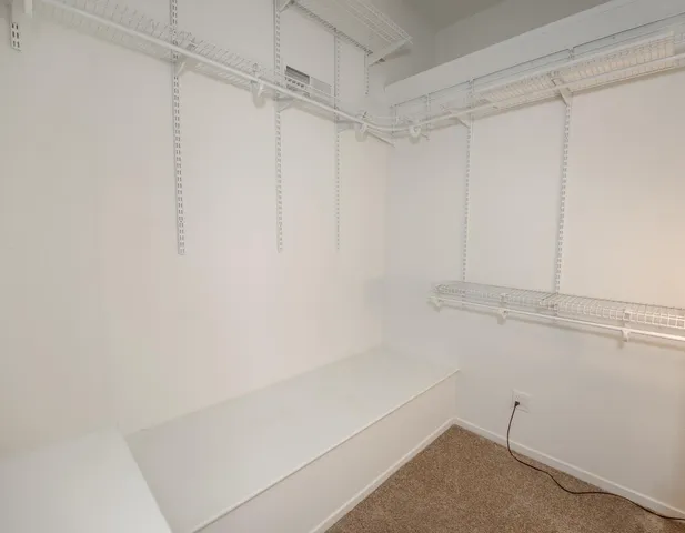 a view of a patio with table and chairs potted plants and floor to ceiling window