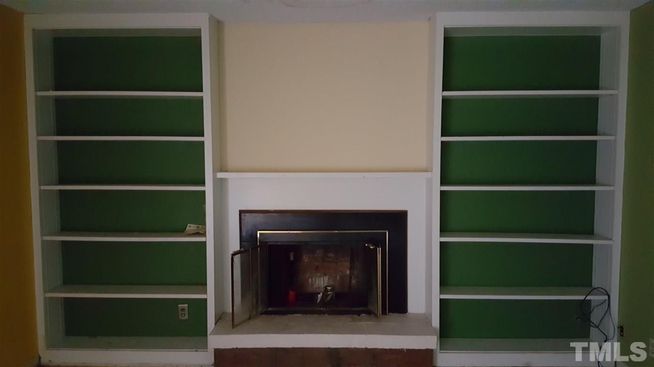 3088 Colony Road, Unit D Durham, NC 27705 - Photo 5 of 11 a living room with a fireplace and a book shelf