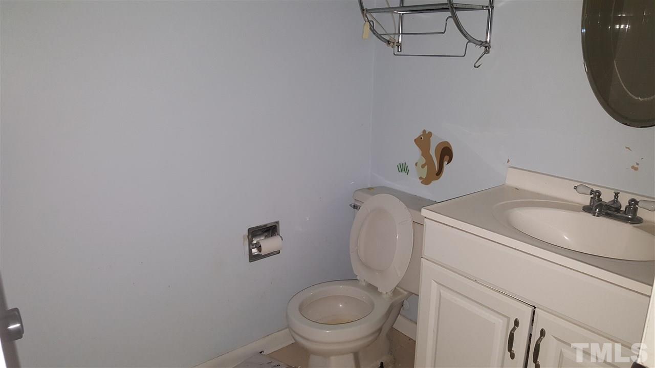 3088 Colony Road, Unit D Durham, NC 27705 - Photo 9 of 11 a bathroom with a sink a toilet and a mirror