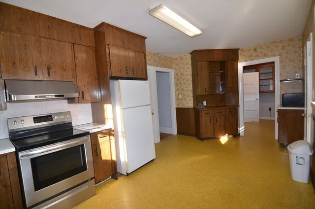 a kitchen with stainless steel appliances a stove a refrigerator and a cabinets