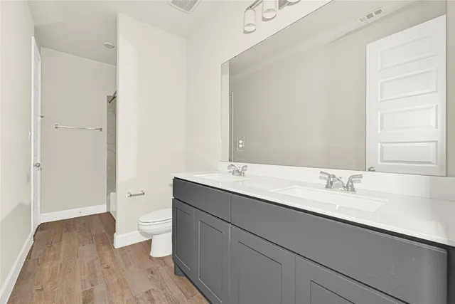 a bathroom with a granite countertop toilet a sink and a large mirror