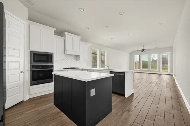 a kitchen with wooden floors and wooden cabinets