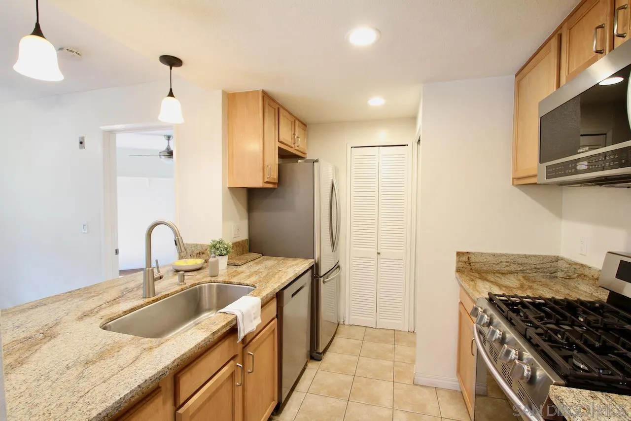 3021 Golden Oak Way Spring Valley, CA 91978 - Photo 3 of 20 a kitchen with kitchen island granite countertop a sink stainless steel appliances and cabinets