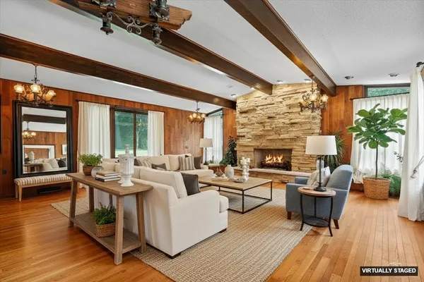 a living room with furniture a fireplace and wooden floor