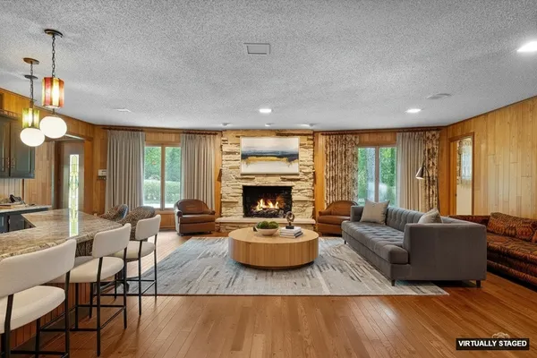 a living room with fireplace furniture and a large window