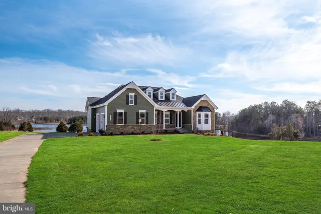 a view of a house with a big yard and large trees
