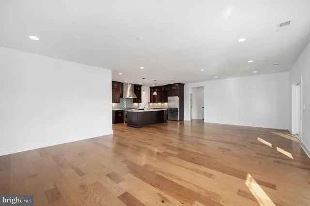 a big room with wooden floor and natural light