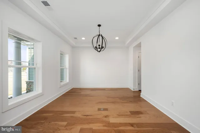 a view of empty room with wooden floor and window
