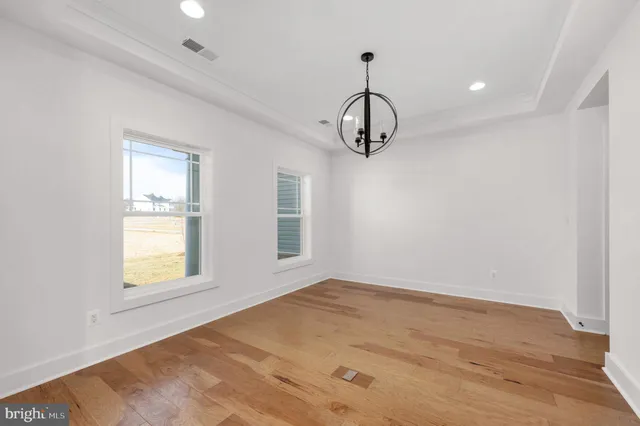 an empty room with a window and wooden floor
