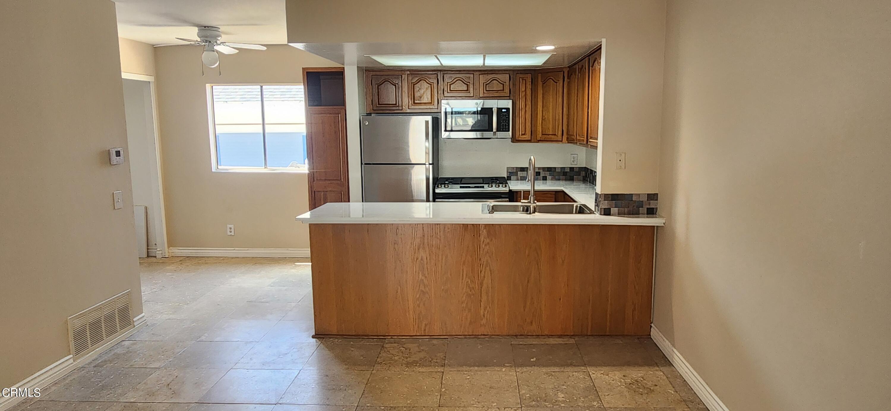 551 South E Street Oxnard, CA 93030 - Photo 3 of 18 a kitchen with kitchen island a counter top space a sink stainless steel appliances and cabinets