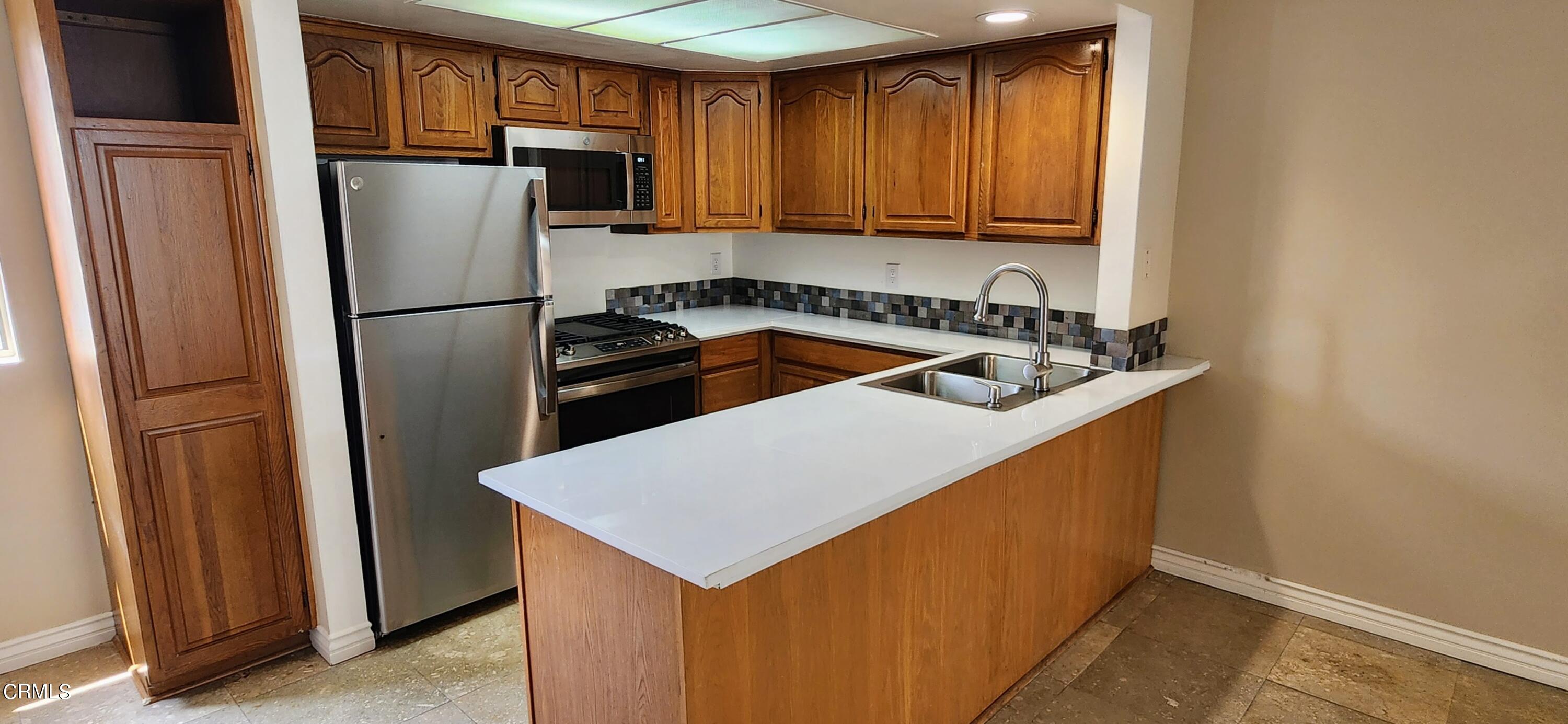551 South E Street Oxnard, CA 93030 - Photo 4 of 18 a kitchen with refrigerator and cabinets