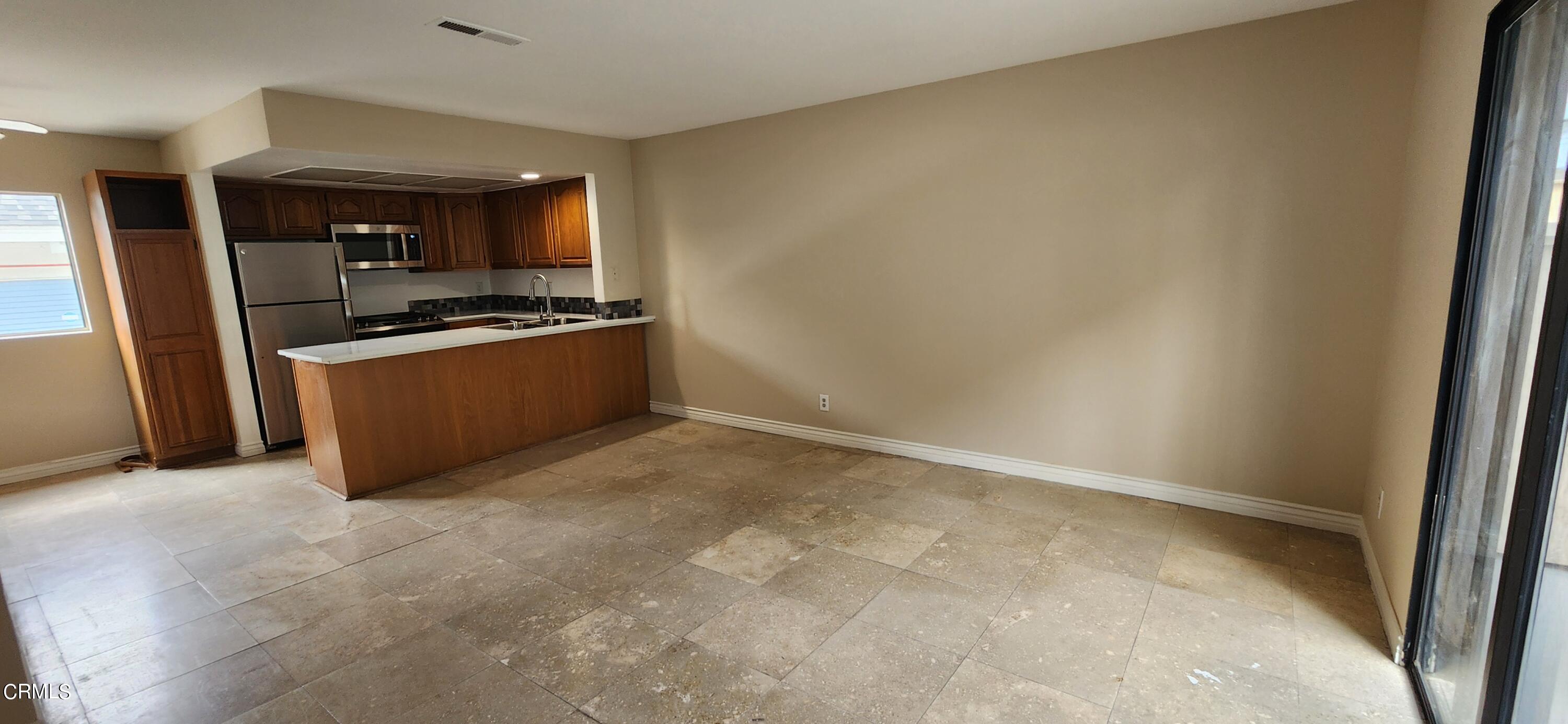 551 South E Street Oxnard, CA 93030 - Photo 7 of 18 a large white kitchen with stainless steel appliances a refrigerator
