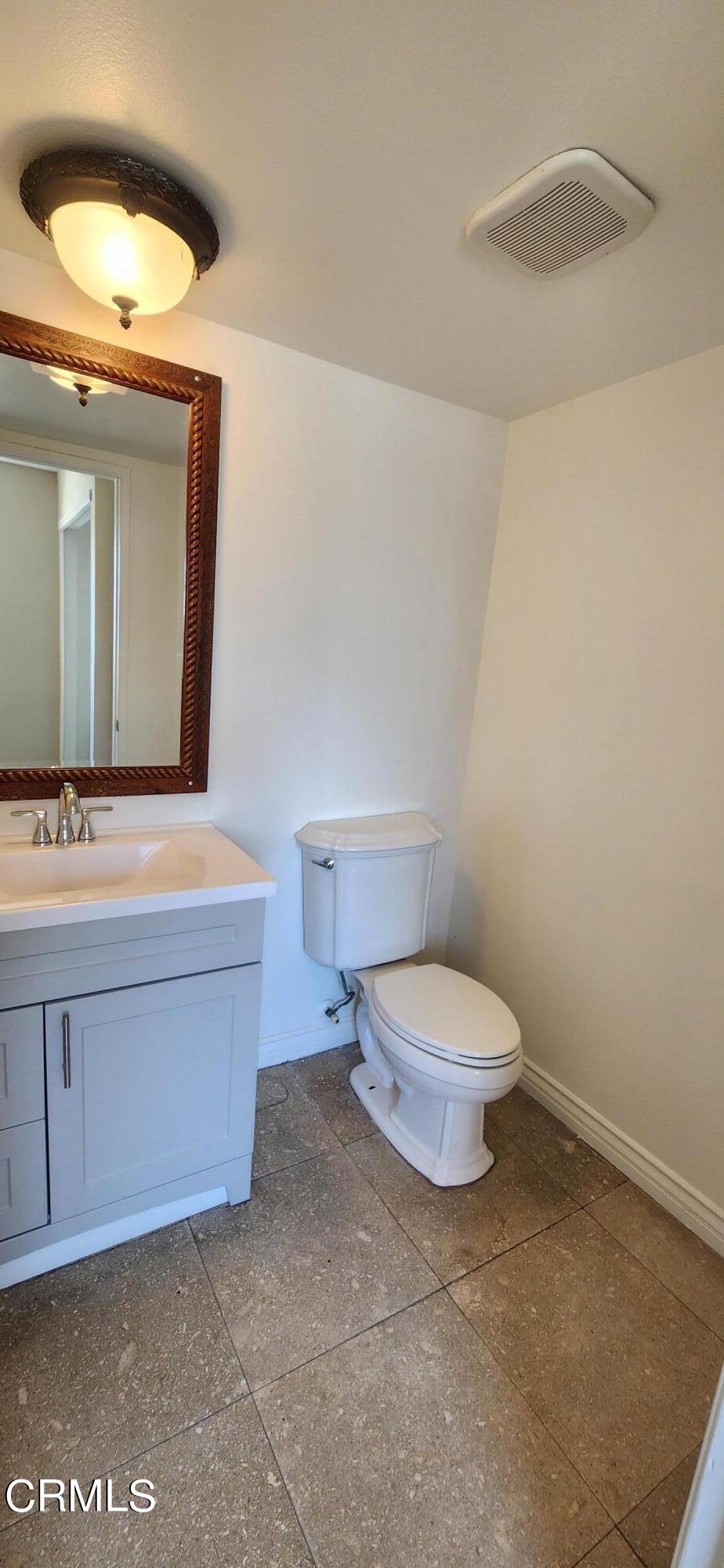 551 South E Street Oxnard, CA 93030 - Photo 10 of 18 a bathroom with a toilet a sink and mirror