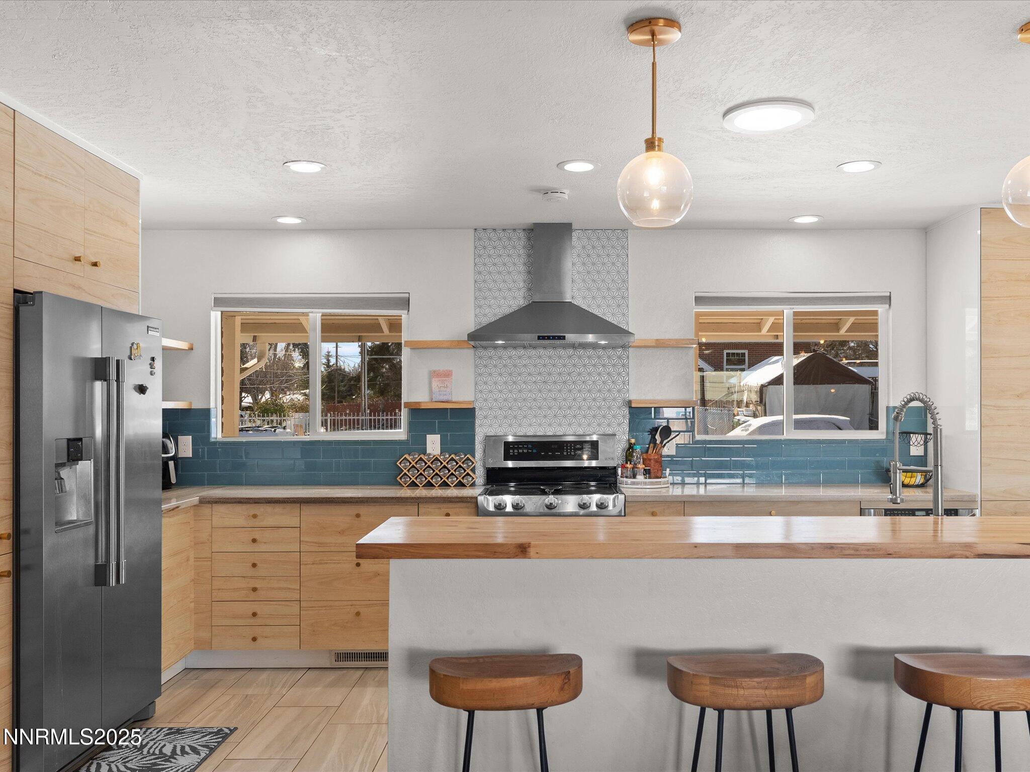 301 Hillcrest Drive Reno, NV 89509 - Photo 14 of 40 a kitchen with stainless steel appliances granite countertop a sink a stove a refrigerator cabinets and chairs