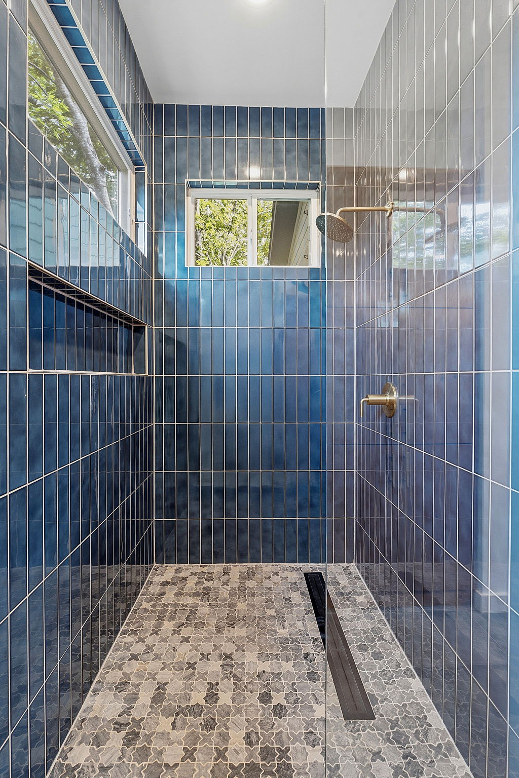 1707 Deloney Street, Unit 2 Austin, TX 78721 - Photo 4 of 26 Step into a refreshing shower oasis featuring striking blue tilework and a patterned floor.