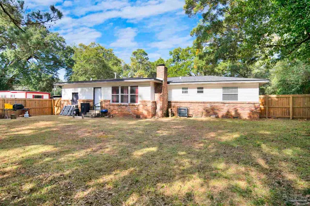 a view of a house with backyard and a tree