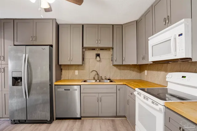a kitchen with a sink a refrigerator and cabinets