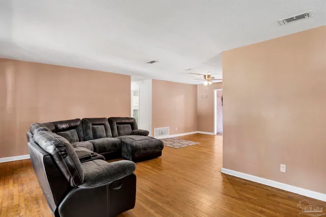a living room with furniture and a wooden floor