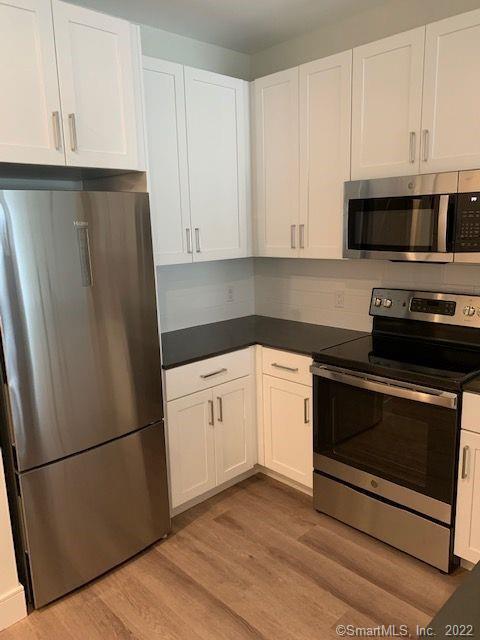 10 A Willard Road, Unit 219 Norwalk, CT 06851 - Photo 1 of 1 a kitchen with stainless steel appliances a refrigerator stove and cabinets