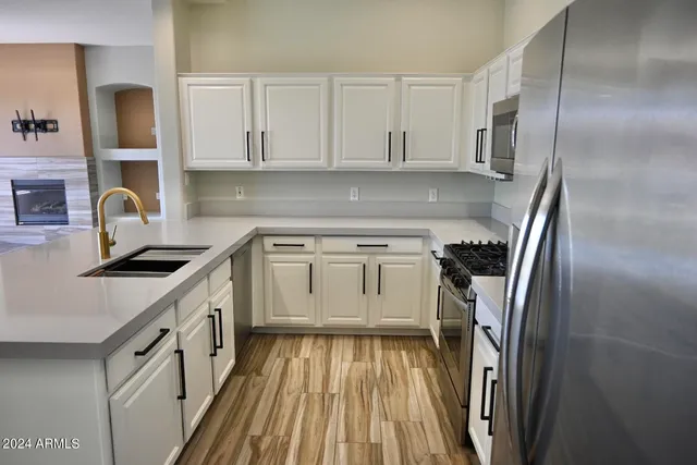 a kitchen with cabinets and a stainless steel refrigerator stove