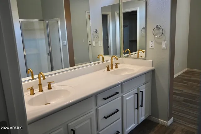 a bathroom with double sink and two mirror