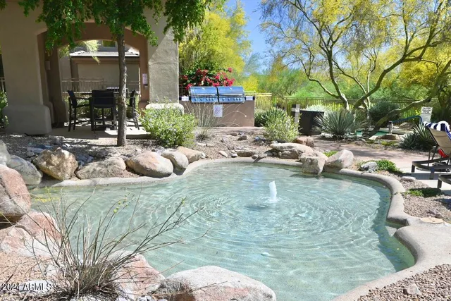 a front view of a house with garden and sitting area