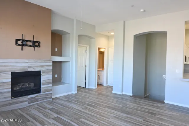 a view of a livingroom with a fireplace and wooden floor