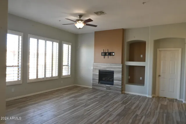 a view of an empty room with a fireplace and a window