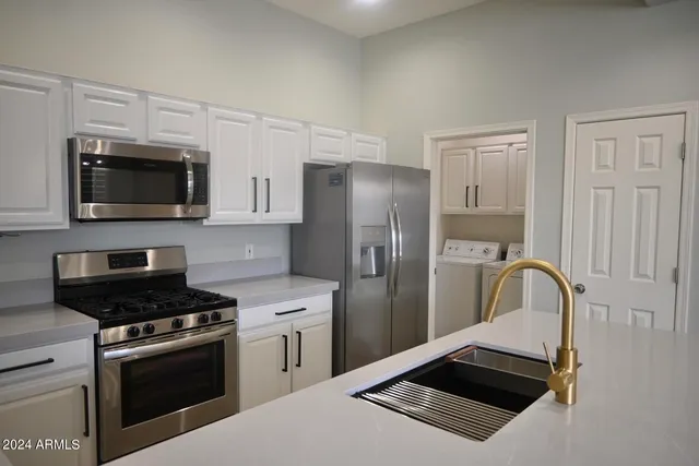 a kitchen with stainless steel appliances a refrigerator stove and microwave