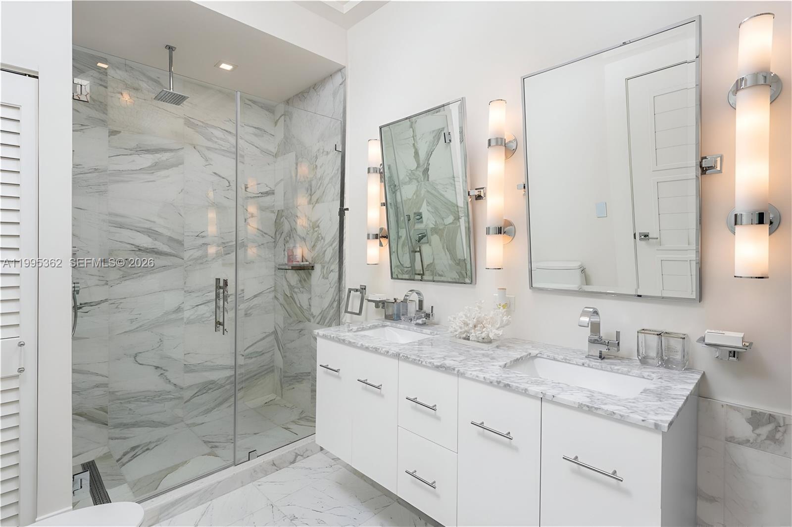 2575 Pine Tree Drive Miami Beach, FL 33140 - Photo 19 of 32 a bathroom with a granite countertop sink mirror and shower