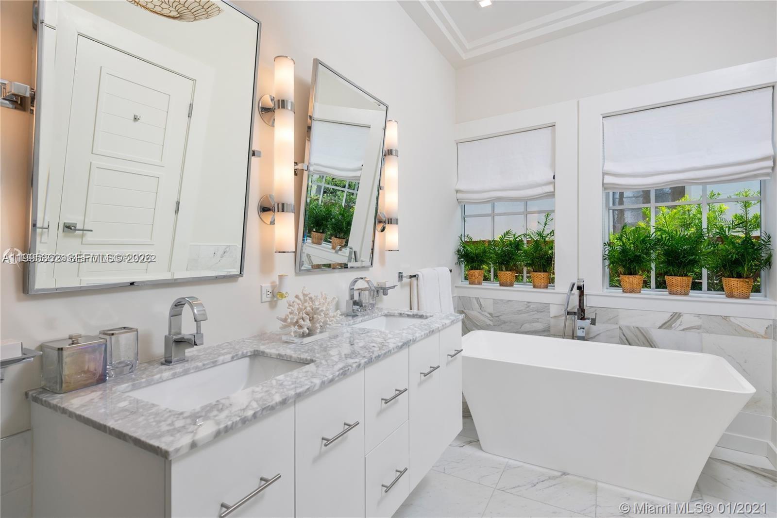 2575 Pine Tree Drive Miami Beach, FL 33140 - Photo 20 of 32 a bathroom with sinks granite countertop a sink and a mirror