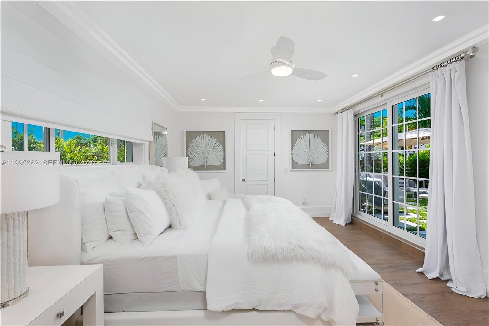 2575 Pine Tree Drive Miami Beach, FL 33140 - Photo 21 of 32 a spacious bedroom with a large bed and a large window
